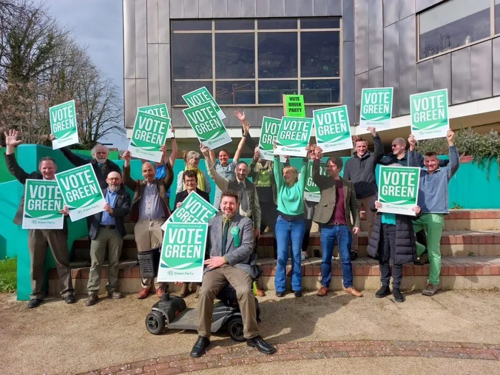 Newly elected Green councillors outside their offices, holding plaques that say "Vote Green"