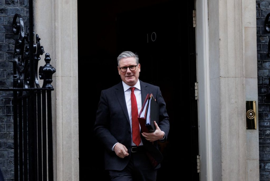 Keir Starmer carrying folders leaving Number 10 Downing St via front door