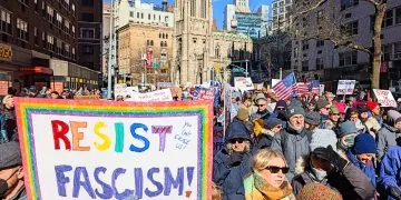 No Kings protest in New York, a woman holds up a placards that says "Resist Fascism"