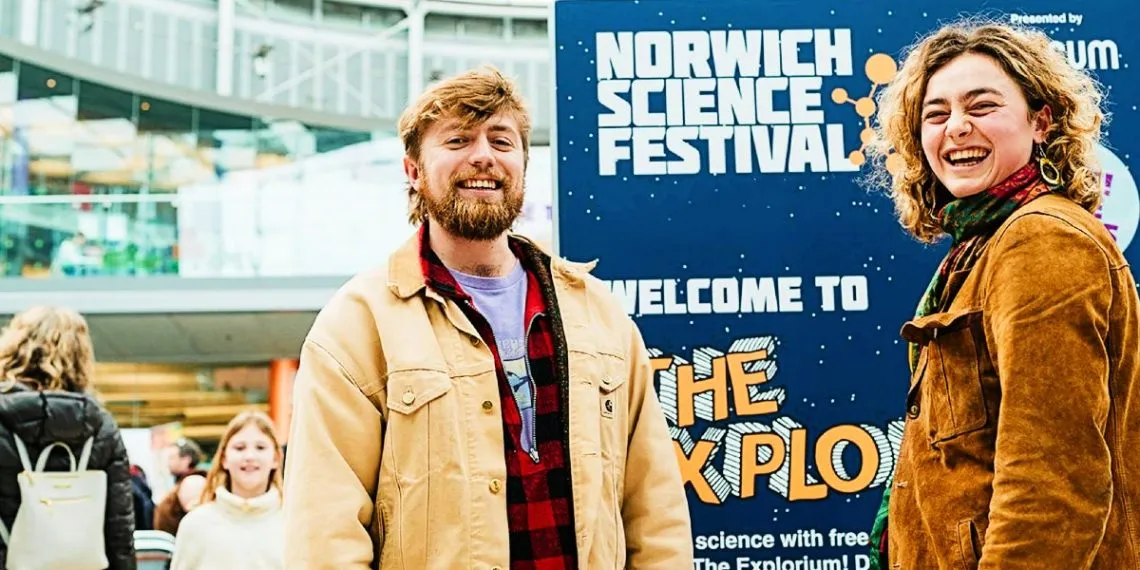 Two young people in the Forum standing in front of a "Welcome to the Explorium" sign